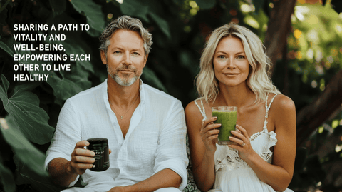 A beautiful couple wearing white, clothes. They are looking into the camera with the man holding a biophotonic jar of EDERRA EMPWR+ and the woman is holding a green drink in a glass. The background is a sunny tree setting like a backyard