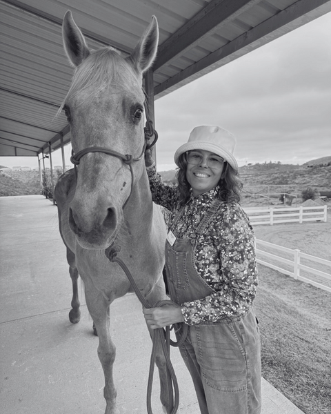 A black and white photo of EDERRA brand ambassador Dr Gloria Rodriguez with a horse on a farm