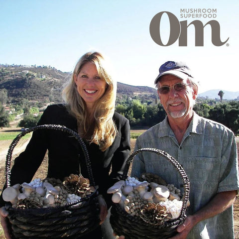 An imagine of two people holding baskets of mushrooms with the Om mushroom superfood logo